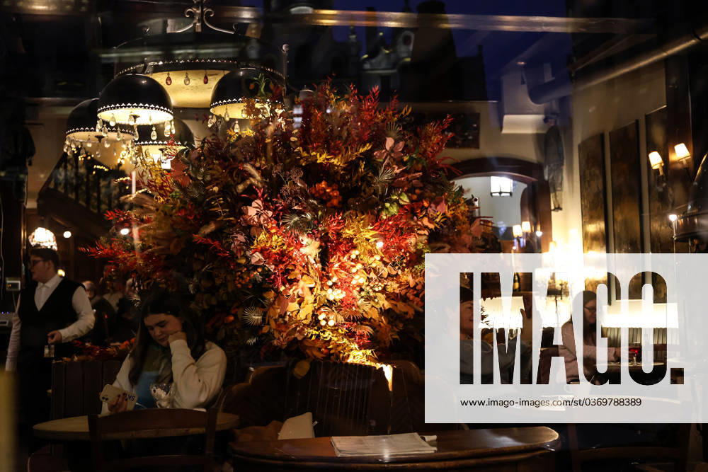 People sitting at tables are seen behind the window of a restaurant decorated with Christmas lights in Brussels, Belgium, November 30, 2023. Brussels Belgium - ZUMAm177 20231130_zip_m177_001