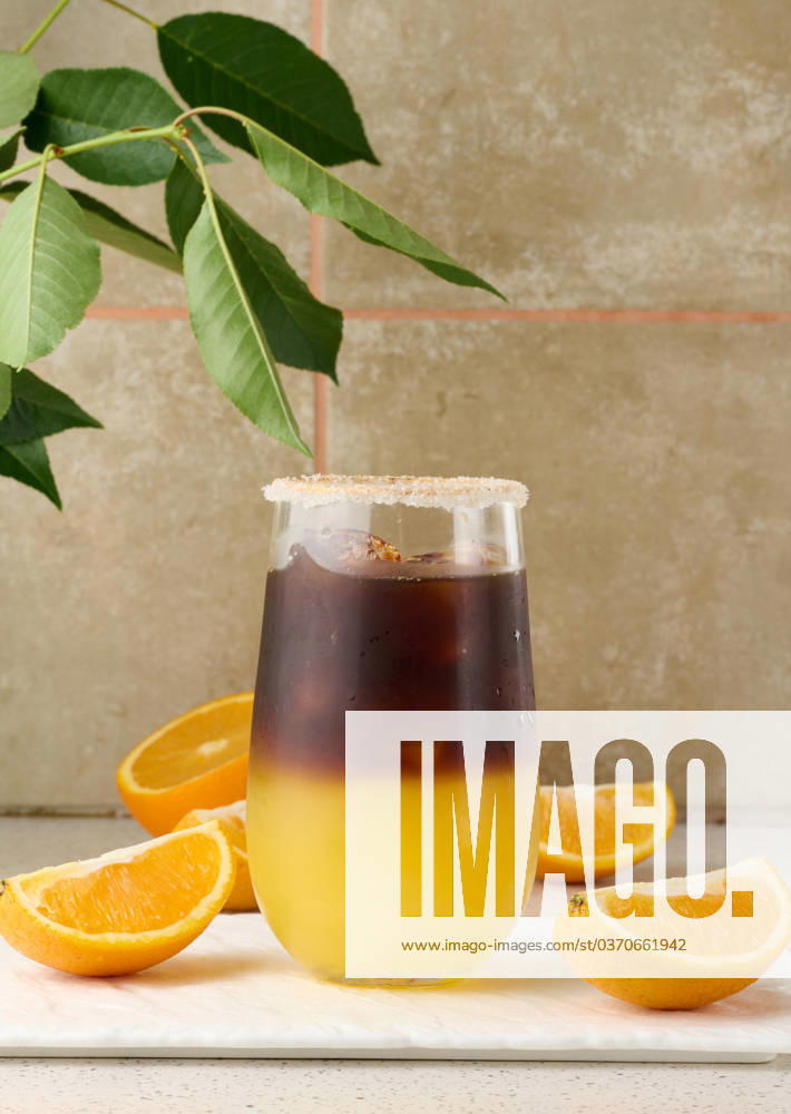 Cold coffee with orange juice in a transparent glass and orange slices Cold coffee with orange juice in a transparent glass and orange slices