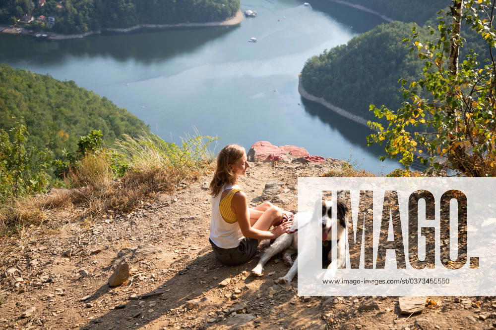 Woman and dog on mountain top overlooking a lake woman and dog on mountain top overlooking a lake ,model released, Symbolfoto