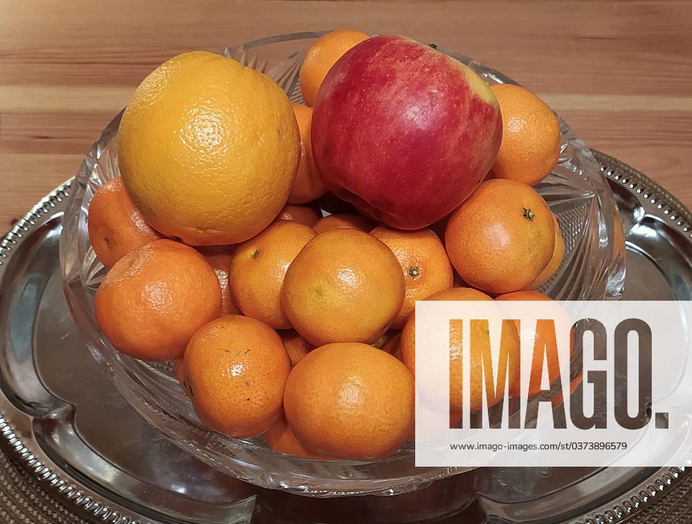 Fruits: apple, orange and tangerines in a vase on the table. VictorxLisitsyn