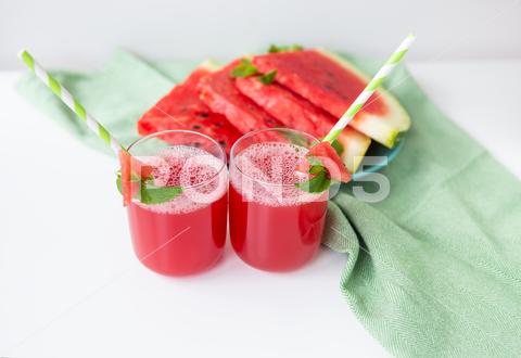 Juicy freshly squeezed watermelon juice in a glass along with a green tube, against a green napkin watermelon glass juice juicy slice smoothie sweet mint drink tube organic healthy napkin summer seeds cold cocktail red refreshment green fruit fresh summertime diet freshness food white table ice close up delicious crushed nobody liquid detox gourmet appetizing mixed vitamin natural shake blender tropical leaf vegetarian nutritious ripe tasty serving
