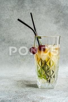 Glass of cold refreshing summer drink with cherry and rosemary sprig placed on gray surface against light background during summer celebration lemonade cocktail glass rosemary drink alcohol cherry beverage refreshment liquid natural celebrate delicious serve ice fresh cold tasty yummy flavor transparent berry cool ingredient thirst clean sour glassware appetizing aperitif fragrant aromatic infuse season decorate herb fruit water citrus liquor lemon slice delectable organic juice mint mix blurred background