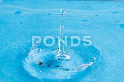 Close up of water drop falling into water with ripples and copy space on blue background. Water, liquid and colour concept. No People Close Water Drop Falling Water Ripple Copy Space Blue Background Liquid Colour Concept Drop Splash Abstract Design Background Wet Flow Fluid Closeup Wave Illustration Macro Business Graphic Symbol Isolated Flowing Color Clean Drink Water Falling Copy Space Blue