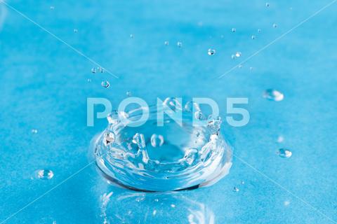 Close up of water drop falling into water with ripples and copy space on blue background. Water, liquid and colour concept. No People Close Water Drop Falling Water Ripple Copy Space Blue Background Liquid Colour Concept Drop Splash Abstract Design Background Wet Flow Fluid Closeup Wave Illustration Macro Business Graphic Symbol Isolated Flowing Color Clean Drink Water Falling Copy Space Blue
