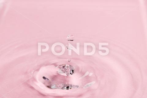 Close up of water drop falling into water with ripples and copy space on pink background. Water, liquid and colour concept. No People Close Water Drop Falling Water Ripple Copy Space Pink Background Liquid Colour Concept Drop Splash Abstract Design Background Wet Flow Fluid Closeup Wave Illustration Macro Business Graphic Symbol Isolated Flowing Color Clean Drink Water Falling Copy Space Pink