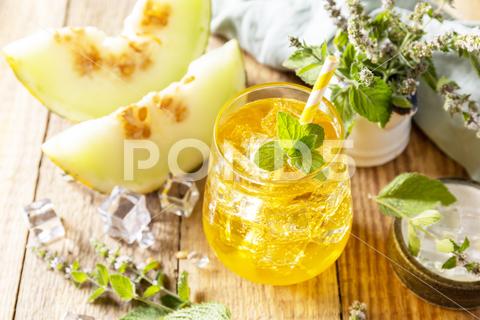 Fresh refreshing fruity summer drink, seasonal beverages. Melon lemonade in glasses with ice and mint on a wooden rustic table. beverage leaf green drink glass ice summer rustic dessert tropical homemade cantaloupe yellow juicy fruit nutrition vitamin delicious nutritious juice tasty wooden water smoothie melon selective orange blended diet ripe vegetarian honey slice beverages lemonade non-alcoholic drinking natural healthy mint freshness food sweet fresh cocktail refreshment background cold organic