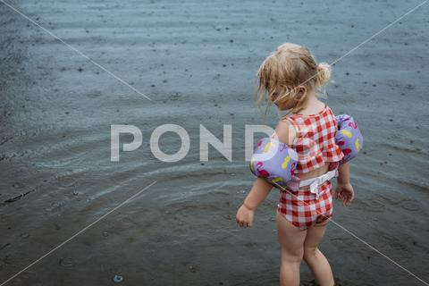 Young girl playing outdoors in the rain in lake 2-4 years age 2-4 atmosphere blue child children cute day droplets early summer environment environmental female fun girl gloomy isolated kid kids lake life jacket life vest messy hair nature one person outdoor outdoors outside play playful playing pouring preschool age rain raindrop raindrops rainy rainy season season summer swimwear texture water weather wet young youth lake boutin state park casual caucasian childhood leisure swimming tourism vacation adventure lake shore wild natural trail of tears travel swim lifestyle shore jackson missouri united states toddler preschool 1-2 years old white