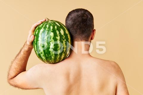 Back view of young man holding fresh watermelon on shoulder over light background watermelon fresh green man harvest sweet juicy healthy food organic ripe fruit diet vegetarian freshness tasty natural agriculture farm garden plant dessert crop field growth red nutrition refreshment striped eating plantation harvesting vegetable delicious snack cultivation farming cultivated gardening environment farmland vitamins nature melon