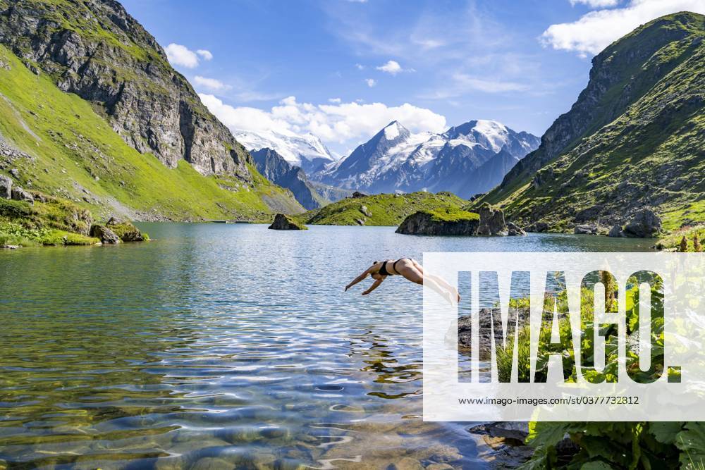 Hechtsprung, Junge Frau mit Bikini springt ins klare Wasser eines malerischen Bergsees, Lac de Louvie, Grand Combin, Walliser Alpen, Wallis, Schweiz, Europa