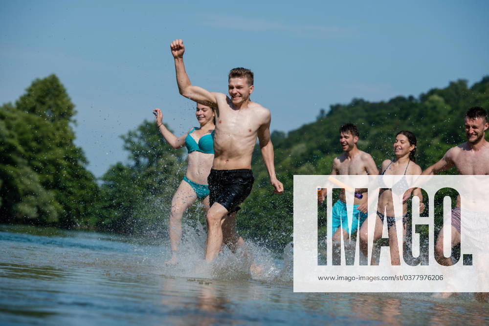 Summer joy friends having fun on river summer joy group of happy friends having fun while running and splashing on river ,model released, Symbolfoto