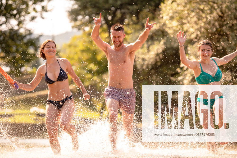 Summer joy friends having fun on river summer joy group of happy friends having fun while running and splashing on river ,model released, Symbolfoto