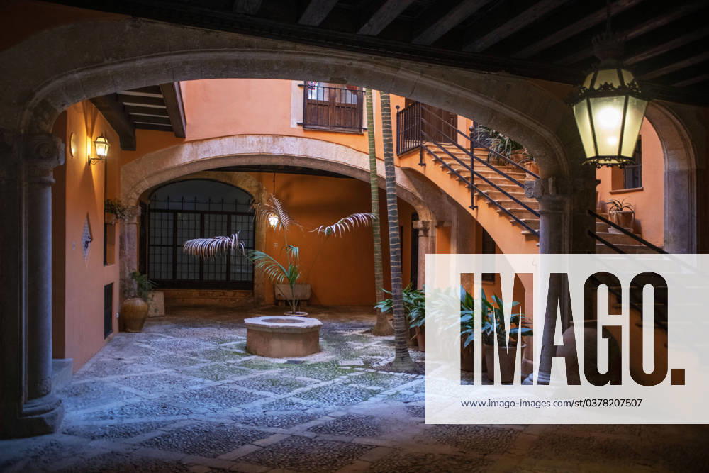 Spain Balearic islands Mallorca Palma de Mallorca Carrer de Can Savella stret Interior of some of the Majorcan patios Mallorca courtyard. Majorcan-style interior patios of some houses on Calle Can Savella. Can Vivot, declared an Asset of Cultural Interest and a Historic-Artistic Monument, has a spectacular stately courtyard populated by three vintage horse-drawn carriages. Behind this impressive entrance hides a no less surprising origin that dates back to the fourteenth century with the union of the raconada d en Berard and l alberg d en Clapà s, houses very close to each other. Prior to that, there is an Arab arch that, according to Montaner, is believed to be the roof of some baths. Mallorca Baleares Spain