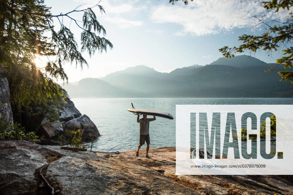 Man carries paddle board on head after an early morning paddle. Squamish, British Columbia, Canada CR_JDIP231218-1200114-01 ,model released, Symbolfoto