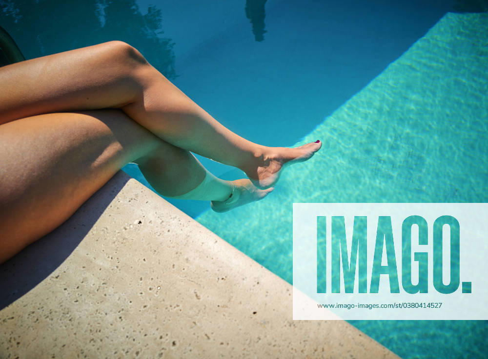 Woman sitting with legs in water and relaxing on poolside model released, Symbolfoto, DIKF00770