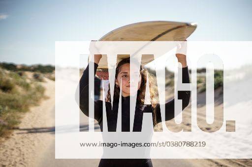 A shallow focus shot of a European female holding a surfboard and walking to the beach 642266 ,model released, Symbolfoto RECORD DATE NOT STATED