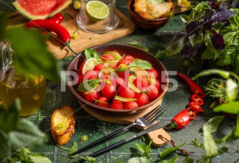 Spicy salad of fresh watermelon balls with basil, lime, rosemary and fennel, topping with olive oil on dark green table surface with sunny light watermelon vegetable summer food healthy salad basil lime rosemary freshness delicious cheese melon table organic epicure vegetarian plate fruit dinner meal sweet green diet red lunch fresh leaf juicy ripe snack herb closeup rustic overhead nourishment eating dish cookery
