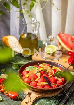 Spicy salad of fresh watermelon balls with basil, lime, rosemary and fennel, topping with olive oil on dark green table surface with sunny light watermelon vegetable summer food healthy salad basil lime rosemary freshness delicious cheese melon table organic epicure vegetarian plate fruit dinner meal sweet green diet red lunch fresh leaf juicy ripe snack herb closeup rustic overhead nourishment eating dish cookery