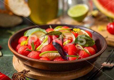 Spicy salad of fresh watermelon balls with basil, lime, rosemary and fennel, topping with olive oil on dark green table surface with sunny light watermelon vegetable summer food healthy salad basil lime rosemary freshness delicious cheese melon table organic epicure vegetarian plate fruit dinner meal sweet green diet red lunch fresh leaf juicy ripe snack herb closeup rustic overhead nourishment eating dish cookery
