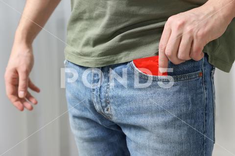 Man pulling condom out of pocket on blurred background, closeup adult aid awareness background blurred care closeup concept condom contraception contraceptive control guy hands health healthcare healthy hiv holding home human illness indoors latex lifestyle male man medical pack package person pocket potency pregnancy prevention protect protection protective pulling red reproduction risk room rubber safe sex sexual venereal virus wrapper