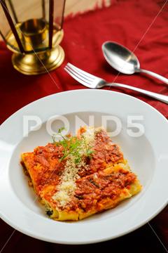 Spicy Tomato and Beef Lasagna served in plate with fork and spoon isolated on red napkin side view of fast food on table delicious spicy spaghetti rustic herb traditional piece lasagna meat beef tomato tomato and beef lasagna beef lasagna tomato lasagna baked meal dinner italian cooked pasta lasagne cheese vegetable sauce cuisine fresh dish basil serving portion food wooden homemade parmesan mediterranean restaurant golden plate lunch served isolated red napkin spoon fork table fast food side view