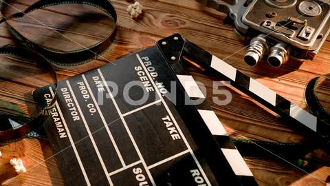 Clapper board, vintage video camera, movie film and3d glasses with popcorn kernels on wooden table. Cinematography Concept clapper board clapperboard action cinematography movie cinema video vintage retro camera 3d glasses popcorn food snack roll tape cinefilm cinematic producer scene film director studio background black blackboard clap take shot production process professional hollywood art antique slate equipment operator broadcast industry media clip multimedia entertainment filming cameraman table wooden