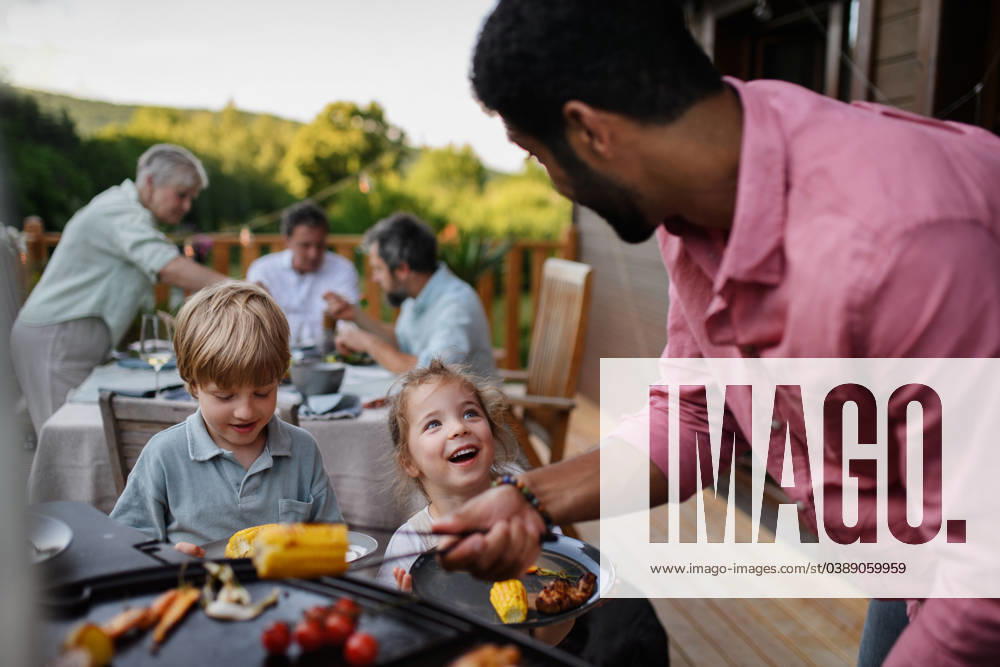 Multi generation family having bbq party outside in the backyard on patio. Multi generation family having party outside in the backyard on a patio. model released