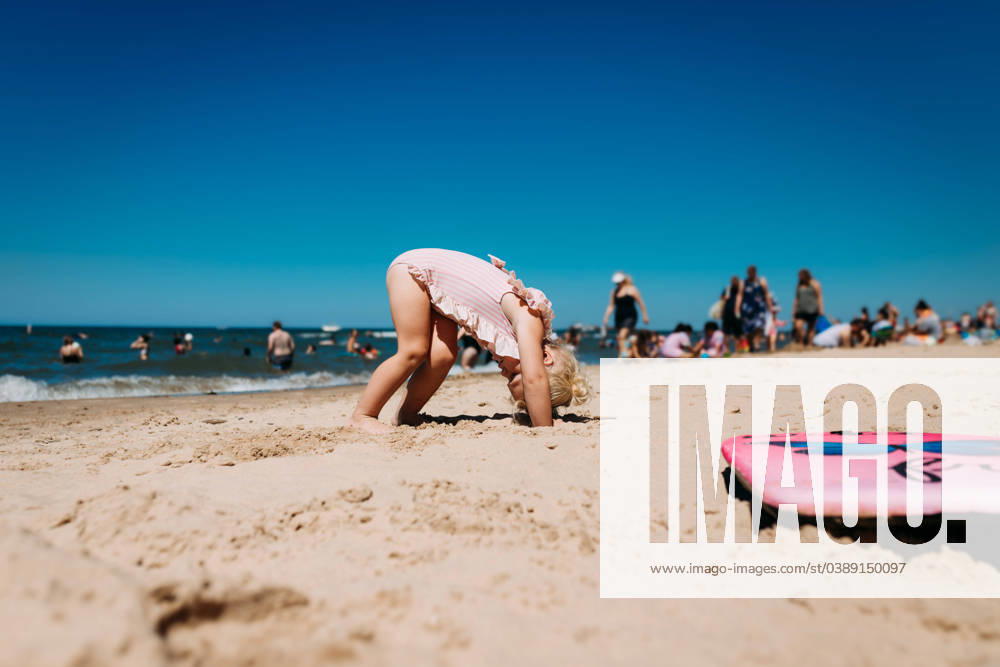 Young child doing downward dog yoga on crowded beach Chesterton, Indiana, United States CR_WEKW240116-1328142-01 ,model released, Symbolfoto