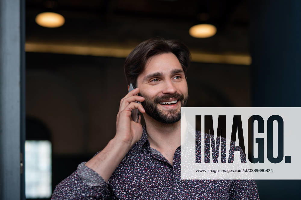 Portrait of young businessman standing indoors, using smarpthone. A portrait of young businessman standing indoors, using smarpthone. model released