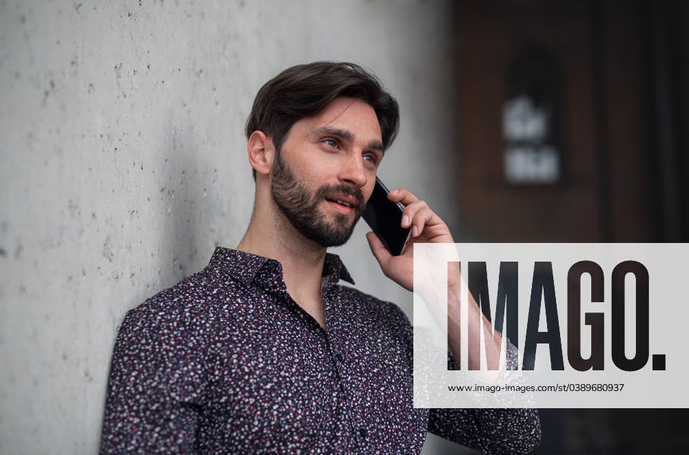 Portrait of young businessman standing indoors, using smarpthone. A portrait of young businessman standing indoors, using smarpthone. model released