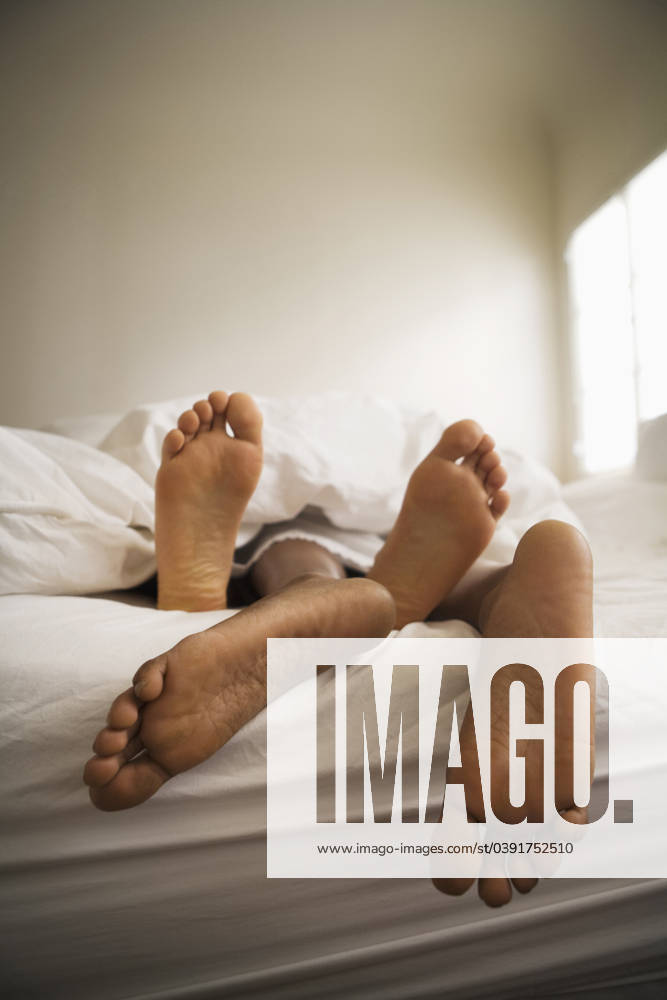 Barefeet of couple laying in bed together Los Angeles, CA, USA, 21.12.2023, model released, TTBB_BLD099031.jpg, african-american ethnicity, attraction, barefoot, bed, bedroom, bonding, boyfriend, color image, comfort, comforter, copy space, domestic life, entwined, girlfriend, heterosexual couple, husband, indoors, intimacy, laying, leisure activity, lifestyle, love, low section, man, mid adult, mid adult couple, mid adult men, mid adult women, people, photography, relaxation, romance, sensuality, sleeping, together, two people, unwinding, vertical, wife, woman,, minority, minorities2, 30s, 30-35, 30-40, 30s, 35-40, adoring, adult, affection, african, african american, african ethnicity, african-american, afro american, afro-american, allu