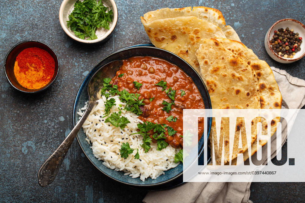 IMAGO Creative, Food, Brot, Naan Traditional Indian Punjabi dish Dal makhani with lentils and beans in black bowl served with basmati rice, naan flat bread, fresh cilantro and spoon on blue concrete rustic table top view Traditional Indian Punjabi dish Dal makhani with lentils and beans in black bowl served with basmati rice, naan flat bread, fresh cilantro and spoon on blue concrete rustic table top view.