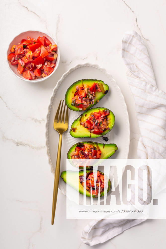 Avocados filled with bruschetta and balsamic vinaigrette - vegan appetizers Avocados filled with bruschetta and balsamic vinaigrette - vegan appetizers