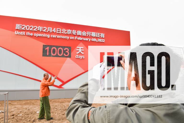 A worker poses for a photo in front of a countdown board reading Beijing 2022 ahead of the 1,000-day countdown to 2022 Winter Olympics on May 8, 2019 in Zhangjiakou, Hebei Province of China. The 2022 Winter Olympics will take place from February 4 to 20 in 2022 in Beijing and Zhangjiakou.