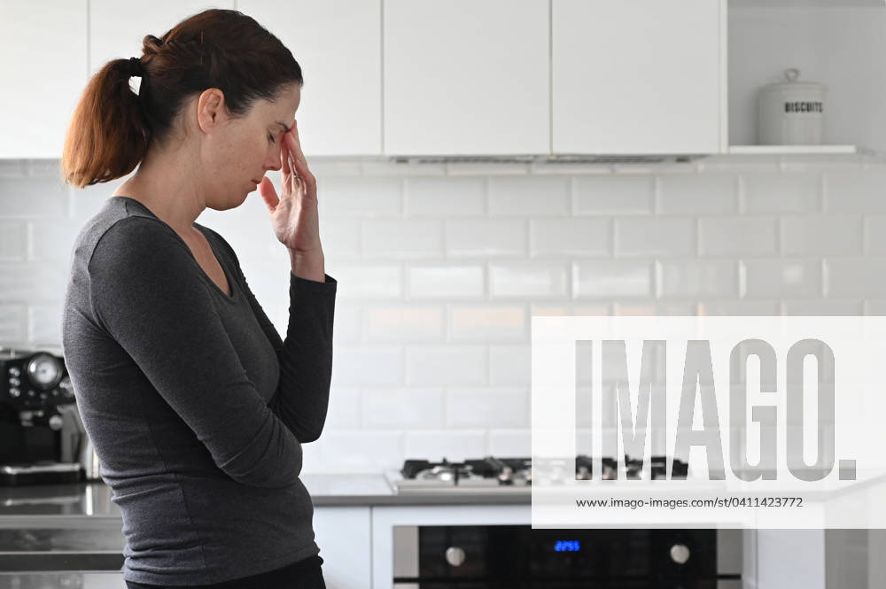Upset woman contemplating in kitchen Upset adult woman contemplating in home a kitchen.