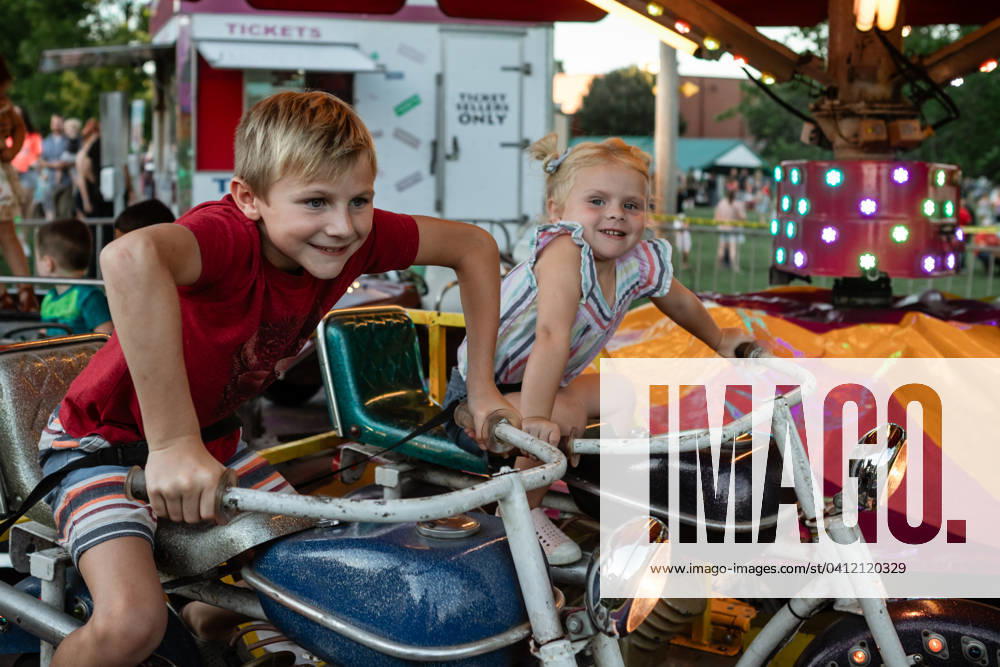 IMAGO Creative, Jahreszeit Sommer, Sommerferien Kids having fun riding carnival ride at summer festival Cobden, Illinois, United States CR_WEKW2402055D-1347888-01 ,model released, Symbolfoto