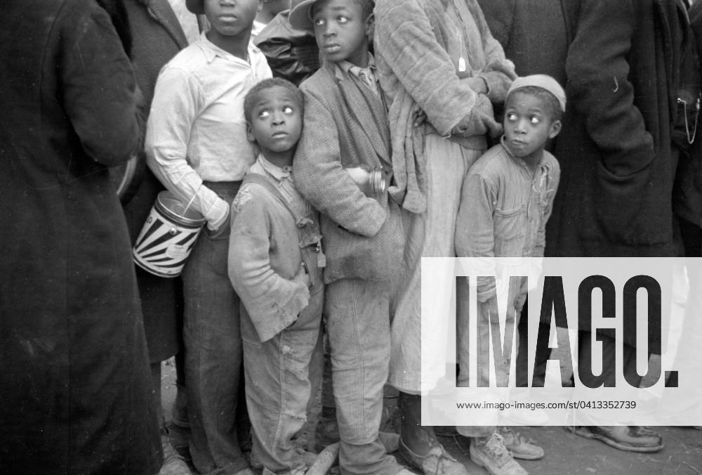 Black american in the lineup for food at mealtime in the camp for flood refugees, Forrest City, Arkansas, 1937 (b w photo) 3666453 Black american in the lineup for food at mealtime in the camp for flood refugees, Forrest City, Arkansas, 1937 (b w photo) by Evans, Walker (1903-75); Private Collection; (add.info.: Photograph taken for the U.S. Resettlement Administration: a New Deal U.S. federal agency that, between April 1935 and December 1936, relocated struggling urban and rural families to communities planned by the federal government.).