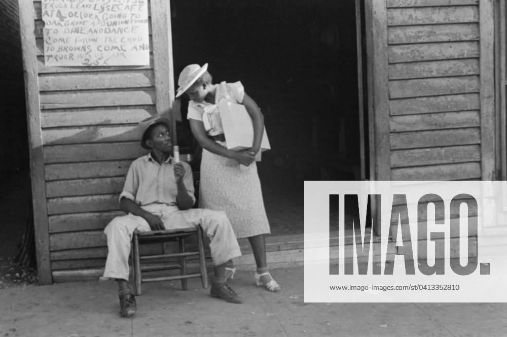Sidewalk scene in Alabama, 1936 (b w photo) 3666460 Sidewalk scene in Alabama, 1936 (b w photo) by Evans, Walker (1903-75); Private Collection; (add.info.: Photograph possibly taken for the U.S. Resettlement Administration: a New Deal U.S. federal agency that, between April 1935 and December 1936, relocated struggling urban and rural families to communities planned by the federal government. ).