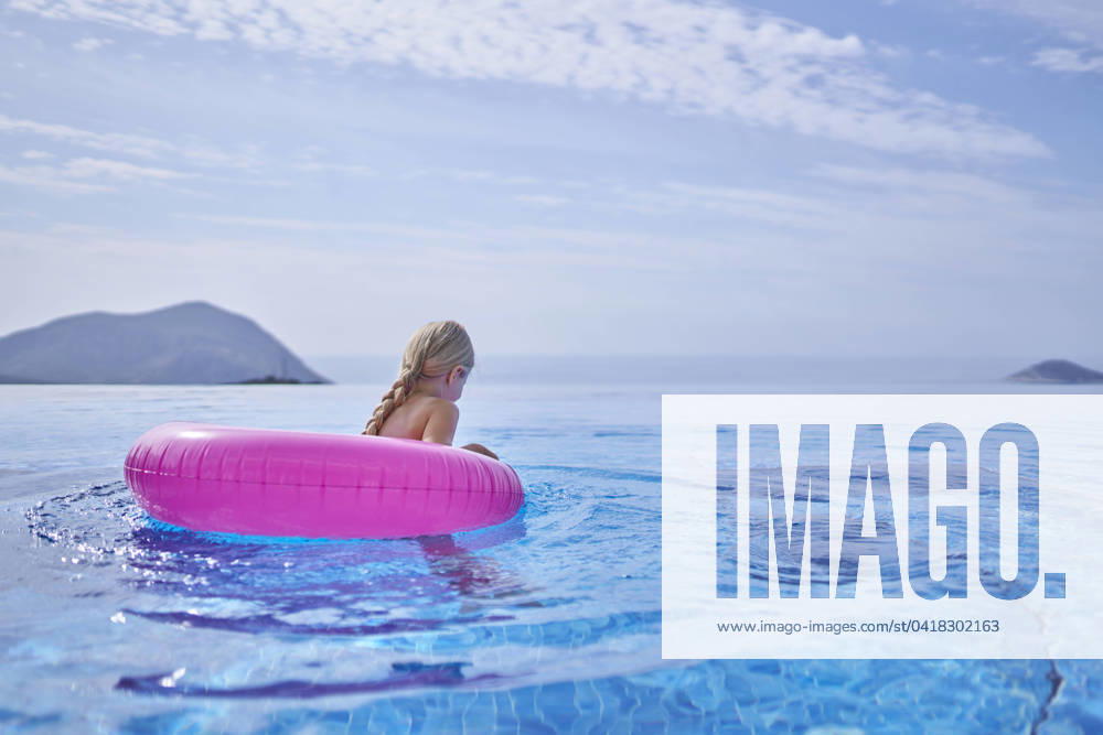 Girl swimming with inflatable tube in blue pool model released, Symbolfoto property released, ANNF00810