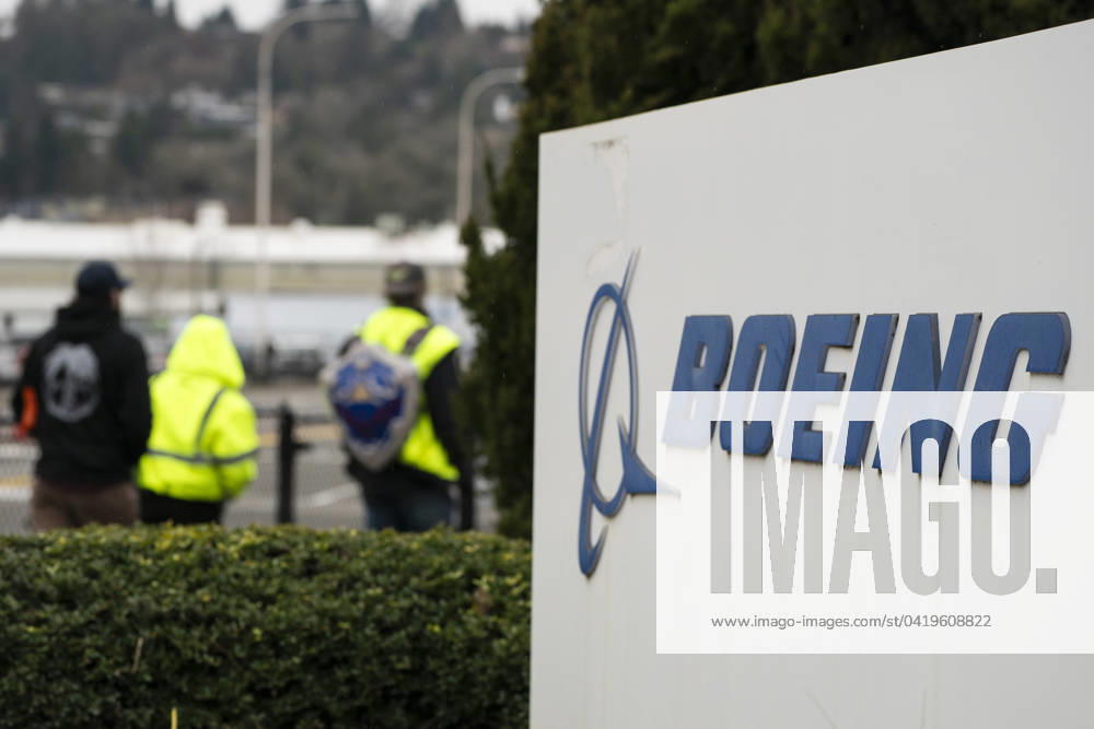 Boeing personnel walk near a Boeing sign outside the Boeing Co. manufacturing facility in Renton, Washington on Feb. 5, 2024. Boeing recently found more mistakes in its 737 Max fuselages. Renton USA - ZUMAr101 20240205_zaf_r101_016