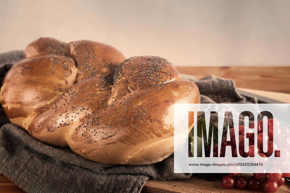 IMAGO Creative: Food, Mohn A loaf of white bread and viburnum berries A loaf of white bread with a crisp crust, sprinkled with poppy seeds, and viburnum berries on the table. Front view, where you want to copy.