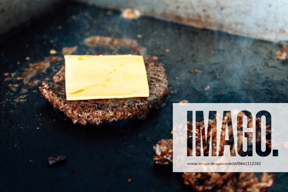 Zubereitung von einem Philly-Cheese-Burger auf einem heißen Grill wird Fleisch und Burgerpatty mit Käse angebraten
