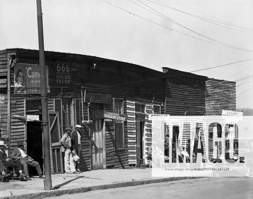 BARBERSHOPS, 1936. A row of African American barbershops in Vicksburg, Mississippi. Photograph, by Walker Evans, 1936.