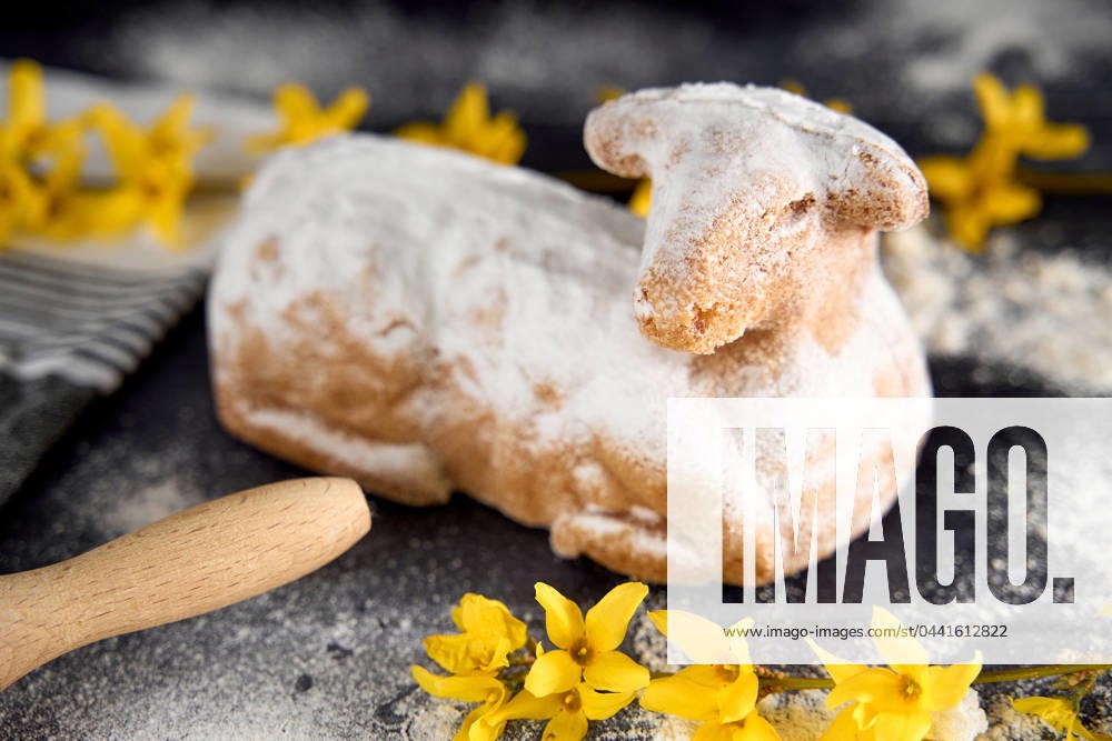Traditionelles Osterlamm als Kuchen zu Ostern. Backen Konzept mit Mehl, Eiern und frischen gelben Blumen