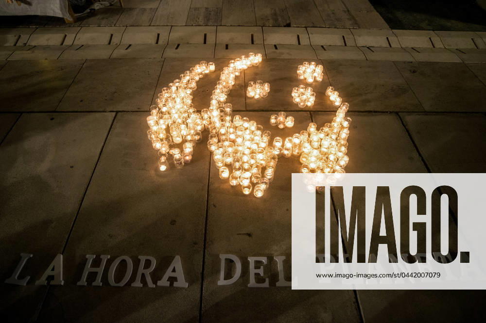 A mosaic made with candles that depicts a panda, the symbol of WWF, is seen on the ground with slogan: La hora del planeta (The hour of the earth) during the Earth Hour in the centre of Malaga. The figure made with candles is a panda, the symbol of the WWF. Thousands of cities worldwide switched off their electric lights during Earth Hour to highlight the dangers of climate change. Malaga Spain - ZUMAs197 20240323_aaa_s197_868