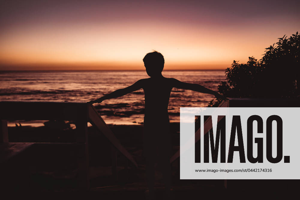 Silhouette of boy with the ocean and sunset in the background United States, California, San Diego CR_CHDO24032266-1361199-01 ,model released, Symbolfoto