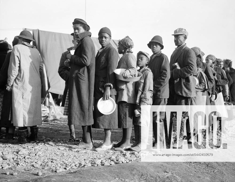 FLOOD REFUGEES, 1937. People waiting in a food line at a flood refugee camp in Forrest City, Arkansas. Photograph by Walker Evans, February 1937.