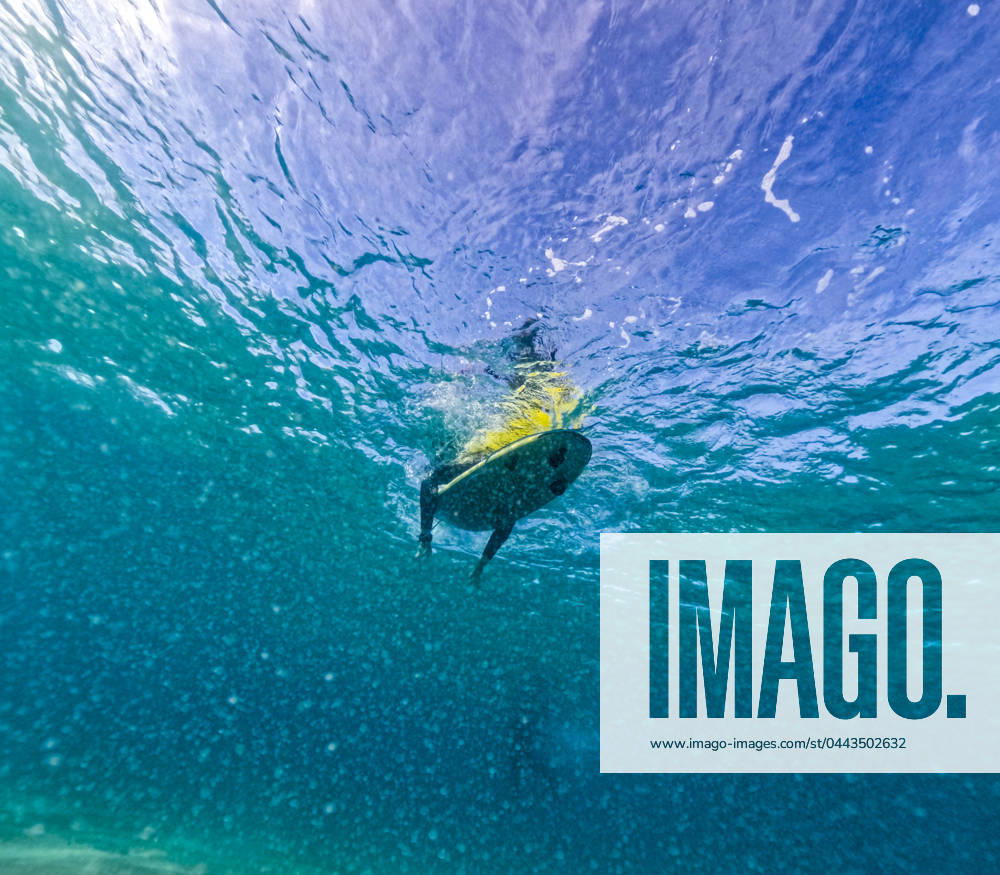 From below underwater perspective capturing a surfer paddling out to the waves in the clear blue waters off the coast of Fuerteventura. Model Released JuanAizpuru_ID20180_597216_013
