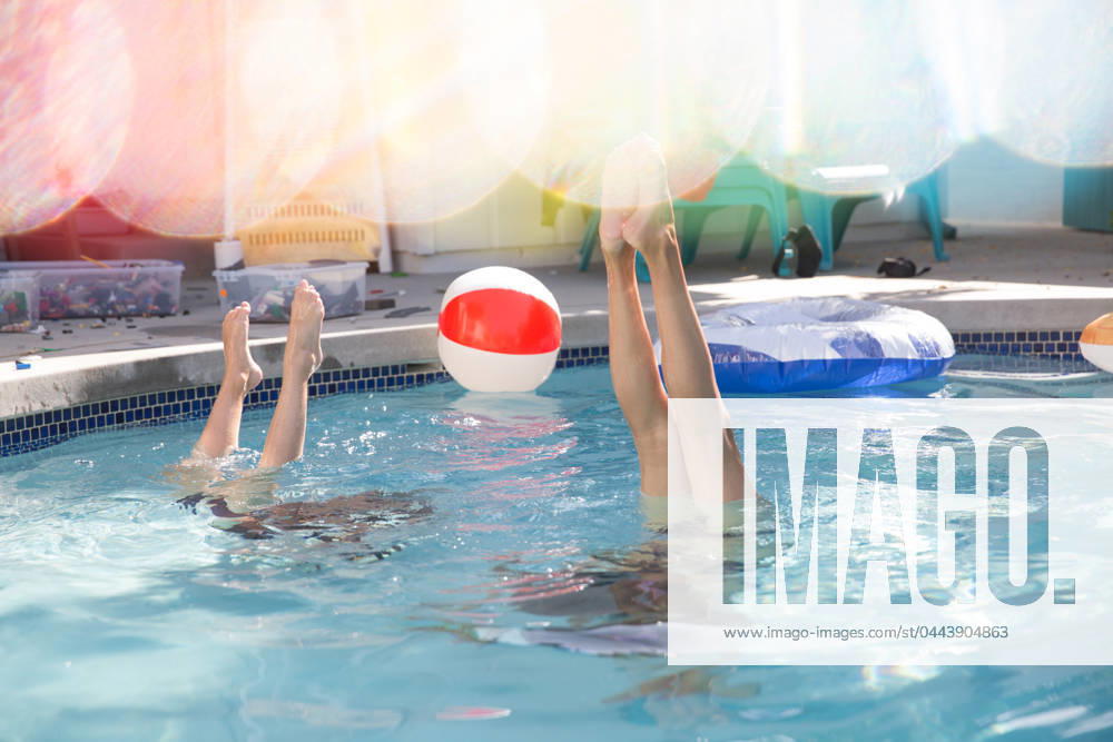 IMAGO Creative, Jahreszeit Sommer, Sommerferien Friends doing handstands in the pool during summer. Ventura, California, United States R_RMAU240404-1372856-01 ,model released, Symbolfoto
