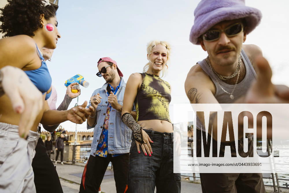 Young non-binary person dancing with friends on promenade in city Germany, Berlin, model released