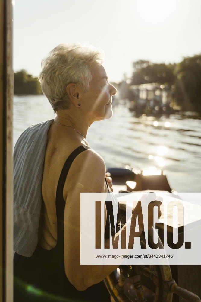 Senior woman steering houseboat on vacation Germany, Berlin, model released, property released